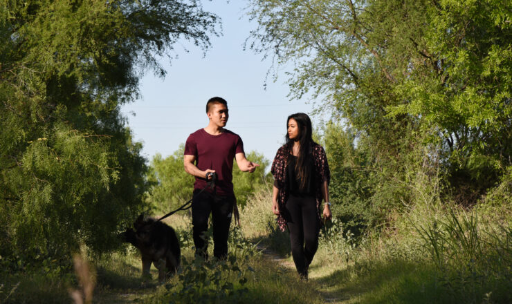 Airman 1st Class Robby Agustin, 47th Operation Support Squadron aircrew flight equipment assistant, Irish Domingo, his spouse, and their dog Momo explore the nature trails at Laughlin Air Force Base, April 23, 2018. The couple enjoys the trails as an alternate to visiting the gym, as well as an opportunity for family time. (U.S. Air Force photo by Airman 1st Class Anne McCready)