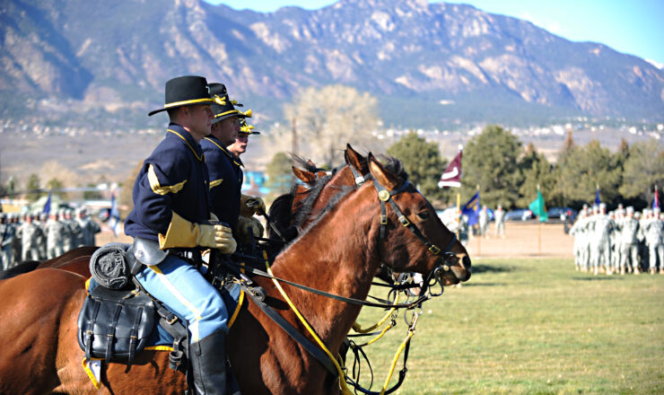 U.S. Army soldiers from the 4th Infantry Division mounted color guard horse ride across the parade field during the division's change of command ceremony at Fort Carson, Colo., Nov. 16, 2011.