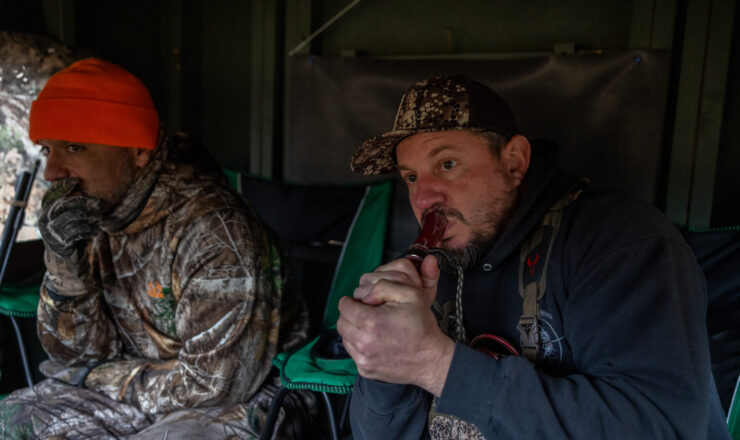U.S. Marine Corps Master Sgt. Paul Starner, right, retired, serving as a volunteer hunting guide for Quantico Injured Military Sportsmen Association, uses a game call to attract deer during a hunting event on Marine Corps Base Quantico, Virginia, Dec. 10, 2022. The QIMSA program provides combat-injured military members undergoing treatment at Walter Reed, Bethesda, or any other hospital in the nation’s capital region the opportunity to realize their hunting and fishing potential, regardless of injury, in the company of fellow veterans and sportsmen. (U.S. Marine Corps photo by Lance Cpl. Jeffery Stevens)