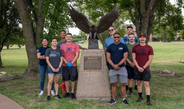 Airmen stand in front of the McConnell Air Force Base monument for the Memorial Walk at McConnell Air Force Base, Kansas, Aug. 26, 2023. The Memorial Walk provides a physical monument for family members and the total force to reflect on the sacrifices made by the deceased service members who built the heritage of the Air Force. (U.S. Air Force photo by Staff Sgt. Adam Goodly)