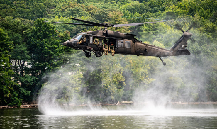 A UH-60 Black Hawk helicopter hovers over a drop site while U.S. Soldiers with a search and rescue unit, 911th Technical Rescue Engineer Company, conduct a helocast training exercise at Fort Belvoir, Va., July 25, 2024. A helocast is an airborne technique that allows Soldiers to insert into an area by jumping directly from a helicopter into water to execute maritime operations. (U.S. Army photo by Cpl. Aaron Troutman)